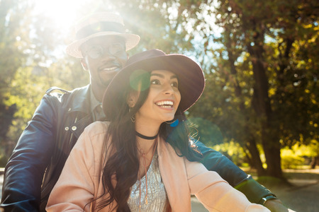 Beautiful interracial couple walking in a park in a sunny dayの写真素材
