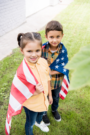 smiling brother and sister with american flagの写真素材