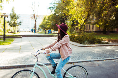 Young woman smiling and riding a bike in a parkの写真素材