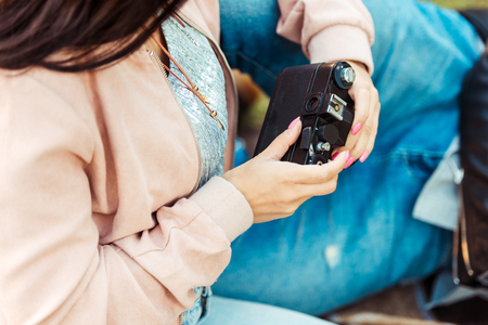 Cropped image of Young woman leaning on boyfriend and holding vintage analogue film camera in her...