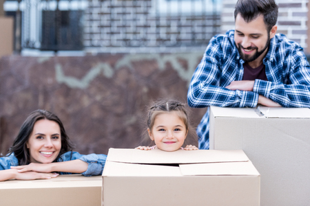 young family with boxes for moving into new homeの写真素材
