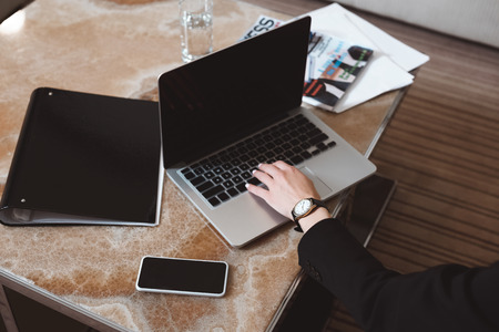 cropped shot of businesswoman using laptop with blank screen in hotel roomの写真素材