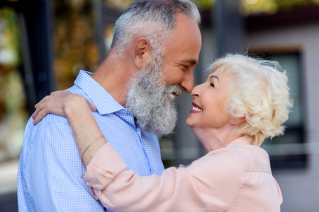 side view of senior man and woman looking at each other on streetの写真素材