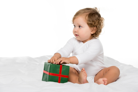 adorable toddler girl with wrapped present isolated on whiteの写真素材