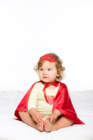 pretty toddler girl in superhero costume isolated on whiteの写真素材