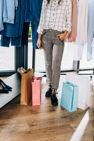 cropped shot of stylish woman with shopping bags in clothing storeの写真素材