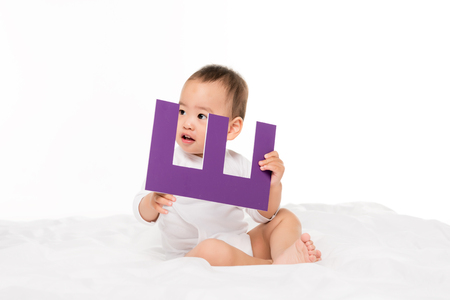 portrait of asian toddler boy with paper letter isolated on whiteの写真素材