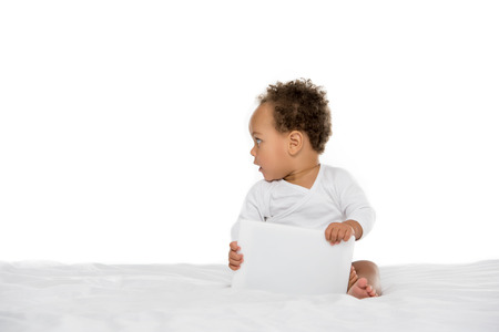 cute african american toddler holding tablet isolated on whiteの写真素材
