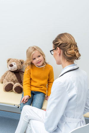 smiling little girl doing neurology examination for female doctorの写真素材