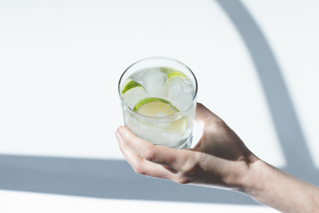 close-up partial view of person holding glass with Gin Tonic cocktail の写真素材