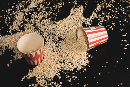 high angle view of popcorn spilled of cardboard bucketsの写真素材