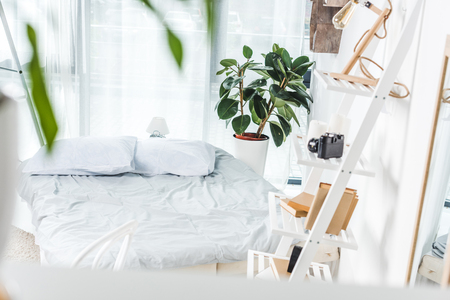 bed with white bedding in cozy bedroom interiorの写真素材