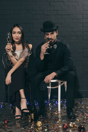portrait of stylish multicultural couple with glasses of champagne at christmas partyの写真素材