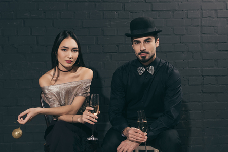portrait of stylish multicultural couple with glasses of champagne at christmas partyの写真素材