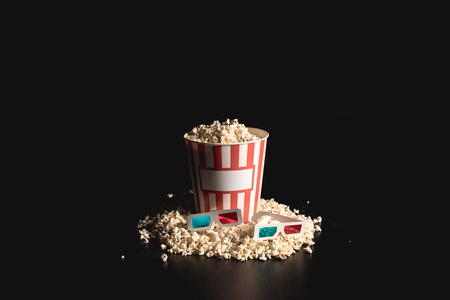 box of tasty popcorn with 3d glasses on blackの写真素材