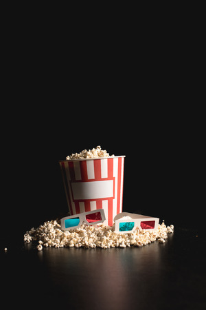 classic bucket of popcorn with 3d glasses on blackの写真素材