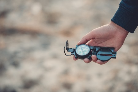 close-up partial view of man holding compass while hikingの写真素材