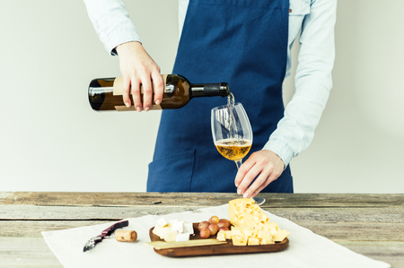 Cropped image of Female sommelier pouring white wine into glass の写真素材
