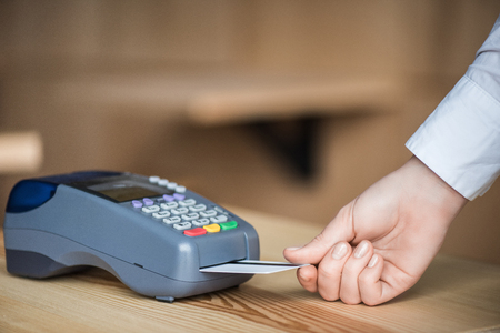 cropped shot of woman putting credit card into edc machine