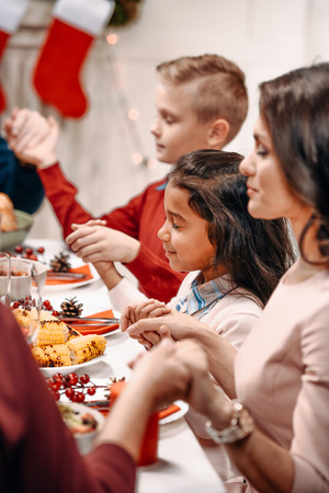 beautiful religious family praying before christmas dinnerの写真素材