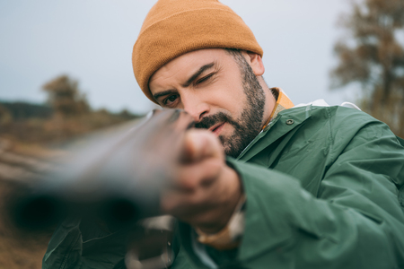 Handsome Hunter aiming at something with a gunの写真素材
