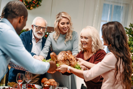 happy large family holding christmas turkey for holiday dinnerの写真素材