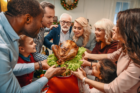 happy large family holding christmas turkey togetherの写真素材