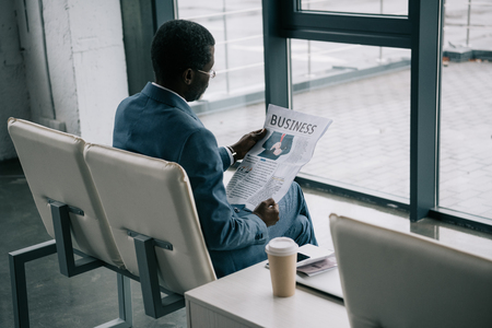African american Businessman reading newspaper in the airport while waiting a departureの写真素材