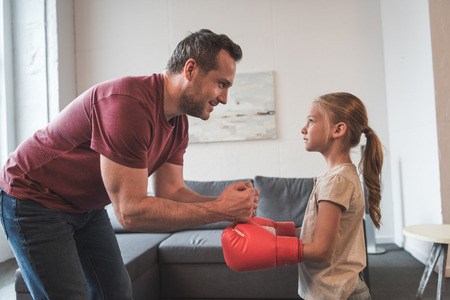 Father teaching daughter boxing at home, self-defence lessonの写真素材