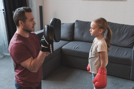 Father teaching daughter boxing at homeの写真素材