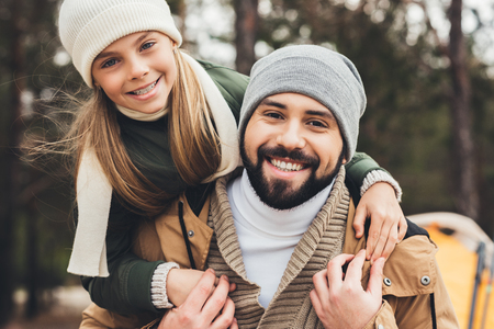 happy little daughter embracing her father on natureの写真素材