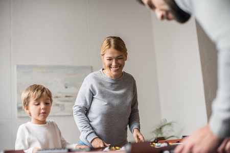 selective focus of parents and son playing table football together at homeの写真素材
