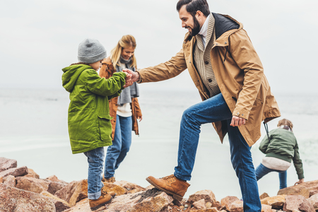 happy family spending time on seashore together on cloudy dayの写真素材
