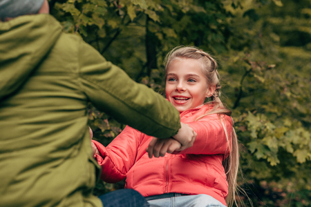 cropped shot of cute little kids holding hands in autumn parkの写真素材