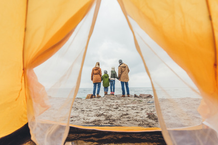 family standing together on seashore and looking at seaの写真素材