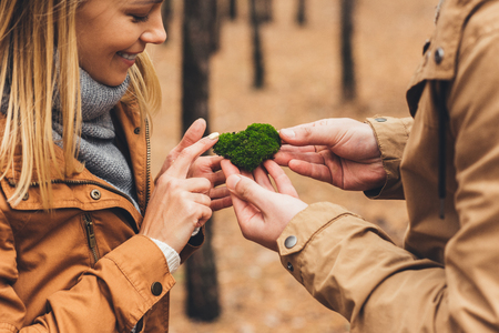 close-up shot of couple touching moss at forest on cold autumn day の写真素材