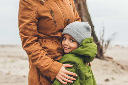 cropped shot of mother and son embracing outdoorsの写真素材