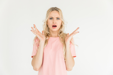 shocked young woman looking at camera isolated on whiteの写真素材
