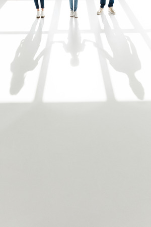 low section of family standing together and shadows on white
