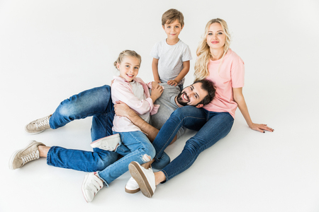 high angle view of happy young family with two kids smiling at camera isolated on whiteの写真素材
