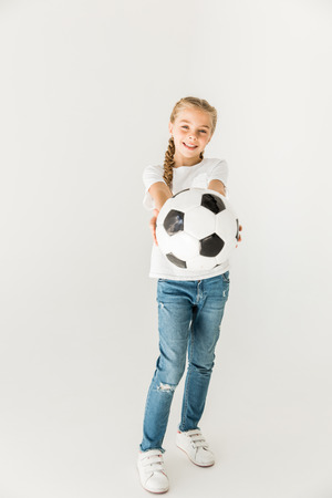 adorable happy kid holding soccer ball isolated on white の写真素材