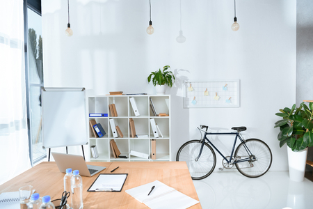 view of empty office interior with table and bicycle against wall の写真素材