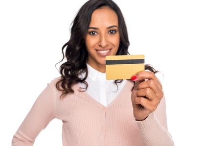 beautiful african american woman holding credit card and looking at camera isolated on whiteの写真素材