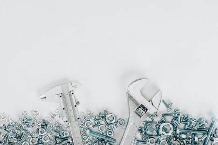 top view of various bolts and framing nails, wrench and vernier caliper set isolated on whiteの写真素材