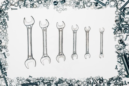 top view of metal wrenches, various bolts and framing nails isolated on white