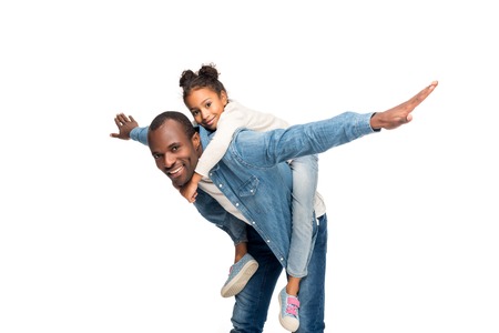 happy african american father piggybacking cute little daughter isolated on whiteの写真素材