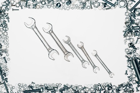 top view of metal wrenches, various bolts and framing nails isolated on whiteの写真素材
