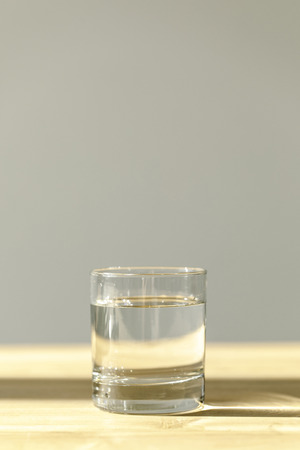 transparent glass with calm mineral water on wooden tableの写真素材