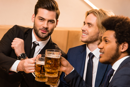 handsome young multiethnic businessmen drinking beer in barの写真素材