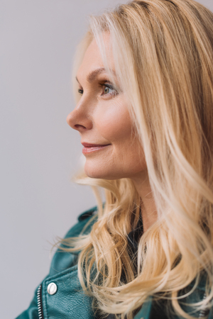 close-up portrait of beautiful mature woman isolated on greyの写真素材